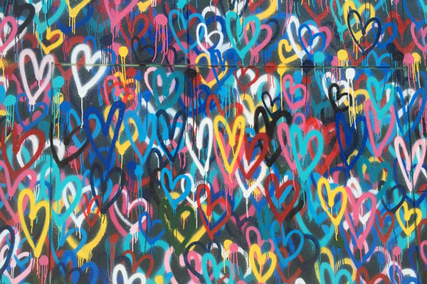 hundreds of spray-painted love hearts on a wall