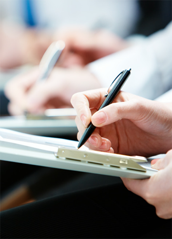 Person writing on clipboard